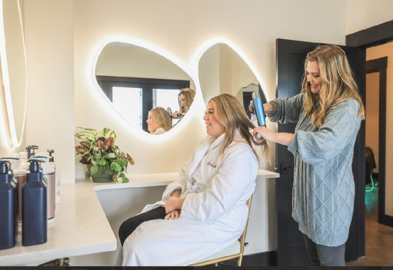 woman getting hair blow dried in a salon setting